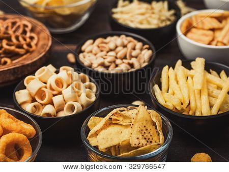 All Classic Potato Snacks With Peanuts, Popcorn And Onion Rings And Salted Pretzels In Bowl Plates O