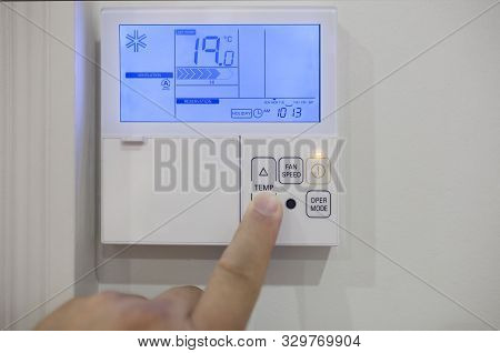 Adjusting Room Climate Control With Electronic Device At Home. Finger Pressing For 19 Celsius Degree