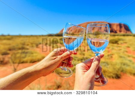 Uluru, Northern Territory, Australia - Aug 24, 2019:toast With Two Glasses Reflecting Ayers Rock In 