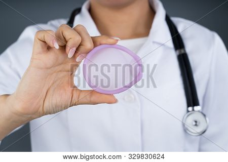 Photo Of Doctor Holding Diaphragm For Contraceptive Use