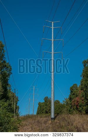 Large And Tall Power Line Towers Cutting Through The Woodlands With A Secondary Line Alongside On A 