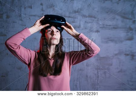 Short Break. A Delighted Girl Holds Virtual Reality Glasses On Her Forehead. She Takes Off, Opens He