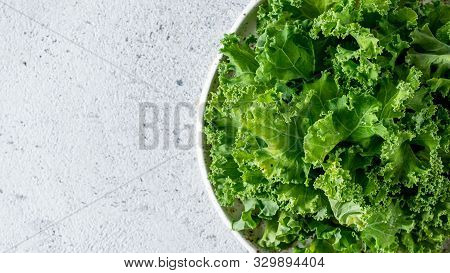 Kale Close Up. Green Vegetable Leaves, Top View In White Craft Bowl Over Gray Cement Background. Hea