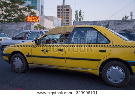 Tabriz, Iran - 11 August 2019 : Taxi, taxi driver and taxi passenger in Tabriz, Iran