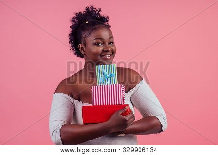 Happy Afro Woman Holding Gift Boxes March 8 In Stusio Pink Background