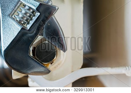 Adjustable Spanner Tightens The Plug Of A Central Heating Radiator.