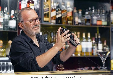 Portrait Elderly Bartender Man With Glasses Holding In Hands A Shaker With A Fresh Delicious Cocktai
