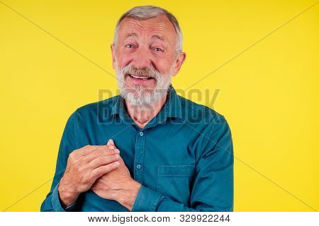 Happy Senior Man Showing Hand Heart Gesture And Smiling, Take Care Of The Health Studio Eyllow Backg