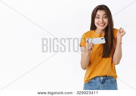 Happy Cute Caucasian Girl Celebrating Victory, Pass Difficult Level In Mobile Game, Holding Smartpho