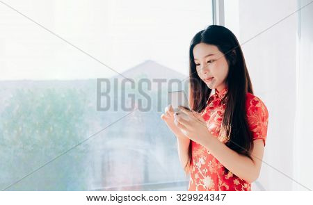 Beauty Asian Woman With Chinese Dress,qipao,cheongsam Chinese New Year Using Smartphone Technology S