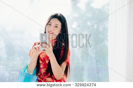 Beauty Asian Woman With Chinese Dress,qipao,cheongsam Chinese New Year Using Smartphone Technology S