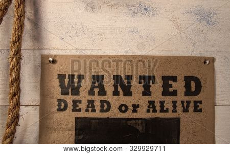 Old Paper Criminal Wanted List On Yellowed Paper Pinned To A Rough Wooden Wall