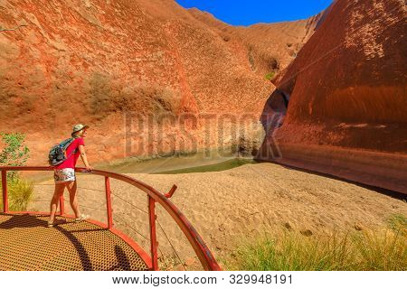 Uluru, Northern Territory, Australia - Aug 24, 2019: Woman At Balcony Looking Mutitjulu Waterhole At