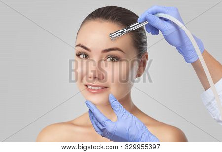 There Is A Woman, Who Is Making The Procedure Microdermabrasion Of The Facial Skin In A Beauty Salon