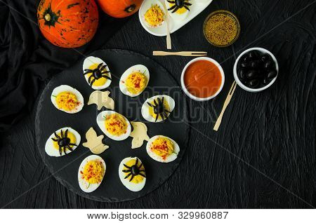 Halloween Stuffed Eggs With Cheese And Mustard On A Black Stone.