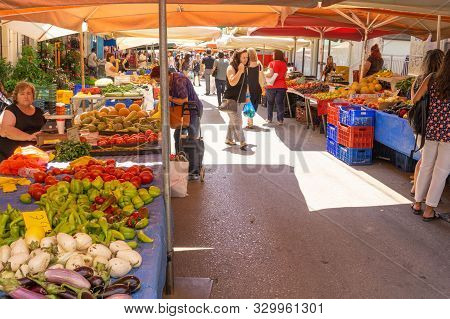 Lamia Greece - July 26 2019; People With Their Purchases Walk Between City Street Market  Produce Ve
