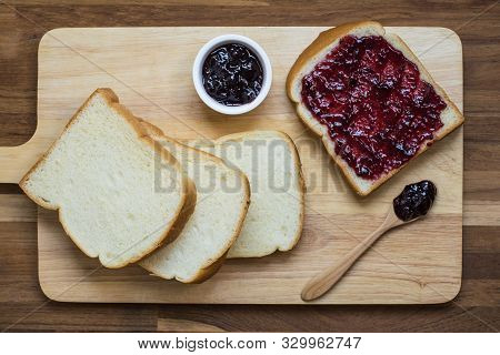 Homemade Bread Slices With Black Currant Jam On The Wooden Board. Top View.
