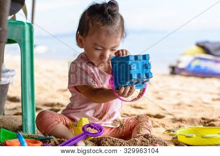 Cute Asian Baby Girl Playing With Beach Toys On The Beach