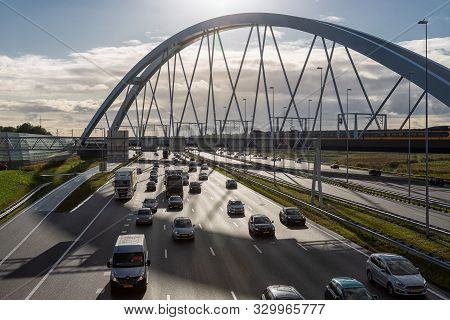 Muiden, The Netherlands - October 03, 2019: Rush Hour At Dutch Motorway A1 Near Amsterdam With Railw