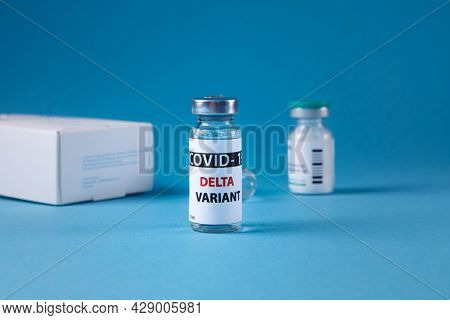 Vaccine bottles covid - 19 delta variant, vials medicine and syringe injection isolated on blue. Coronavirus DELTA 2019-ncov.