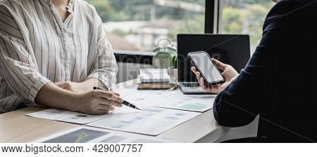 Two Businessmen Are Brainstorming Together And Reviewing The Company Financial Documents That The Fi