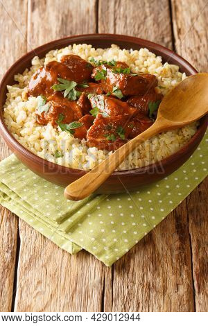 Afelia Cypriot Braised Pork With Bulgur Pilaf Closeup In The Plate On The Table. Vertical