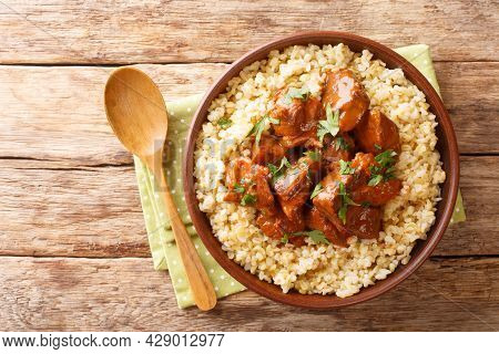 Slowly Braised Pork In Red Wine Served With Bulgur Close-up In A Bowl On The Table. Horizontal Top V
