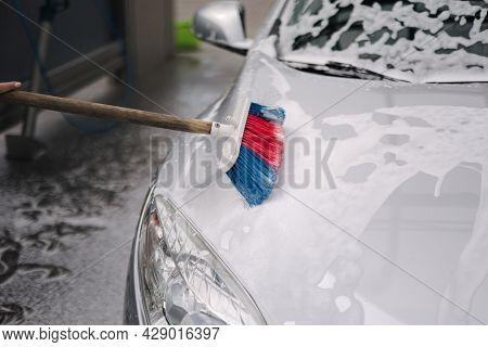 Close Up Of Female Washing The Car With Shampoo And Brushes. Self Car Washing Outdoor. Lather Runs D