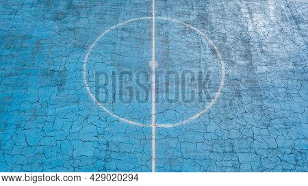 Multi-sport Court With A Central Circle And A Floor Painted Blue And Weathered