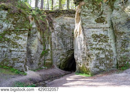 Fragment Of Sandstone Cliff Big Elita With Cave. In Forest In Sunny Day. Beautiful Spring Or Early S
