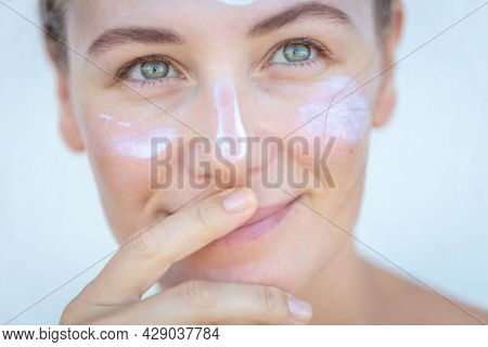 Closeup Portrait of a Nice Blond Female with Cream on a Face. Using Spf. Health Care and Spa. Beauty Treatment Concept.