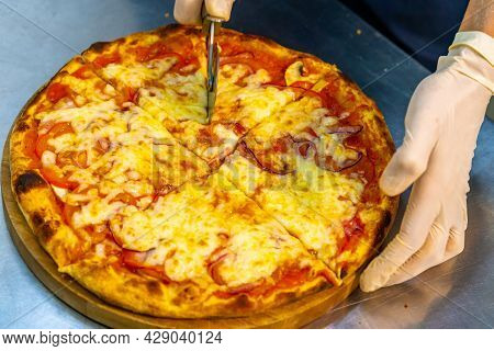 Yummy Fresh Pizza In A Restaurant. Just Now Cooked Pizza From Oven Cutted In Pieces With Pizza Knife
