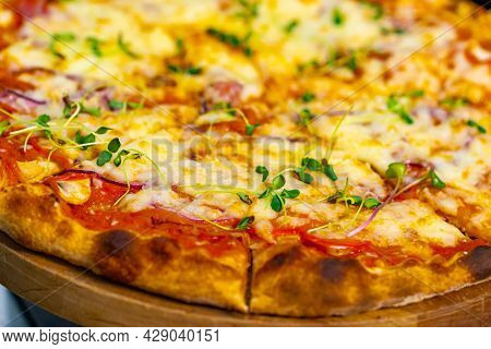 Cropped View Of The Delicious Pizza Served On Wooden Plate. Appetite Pizza At The Restaurant. Stock