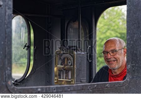 Neuf-brisach, France, June 27, 2021 : Portrait Of Man In Steam Train. A Group Of Volunteers Regularl