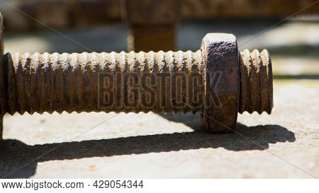 Old Rusty Bolt, Iron Rod With Screw Threads. Rusted Mechanical Components. Threaded Bolt And Nut. Di