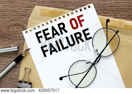 Fear Of Failure. Craft Notebook On Wood Table With Text On Paper And Pen