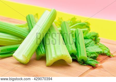 Fresh Celery Stem And Chopped Celery Sticks On Wooden Cutting Board. Vegan And Vegetarian Culture. R