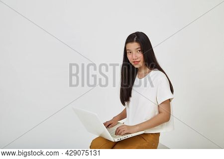 Woman With Laptop Computer Sitting Cross Legged And Looking