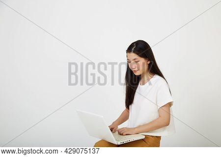 Woman With Laptop Computer Sitting Cross Legged And Looking
