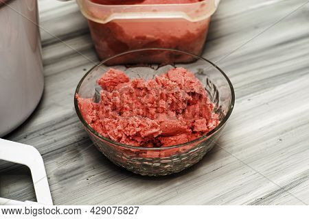 Homemade Cherry Ice Cream In A Glass Socket And A Plastic Container On The Table Next To An Ice Crea