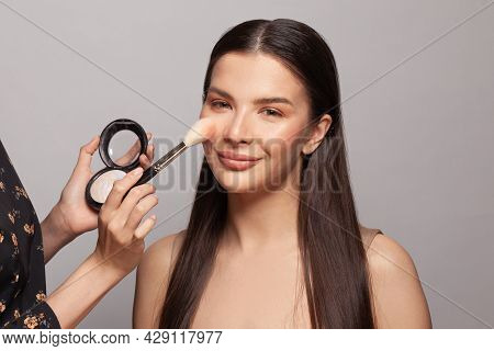 Makeup Concept. Close Up Make-up Artist Hands Applying Powder And Highlighter On Client Skin
