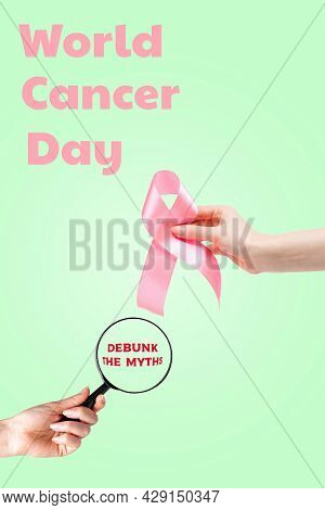 World Cancer Day. Women's Hand With A Pink Ribbon And A Magnifying Glass On A Light Green Background