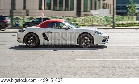 Porsche 718 Boxster S In The City Street. Side View Of White Roadster Car Riding On The Road On High