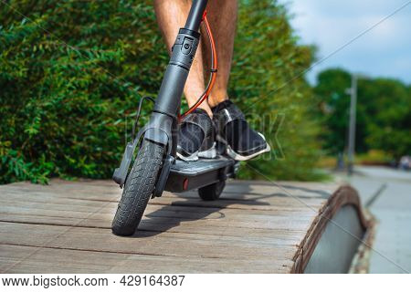 Close Up Of Man Riding Electric Kick Scooter At Beautiful Park Landscape