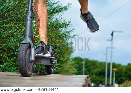 Close Up Of Man Legs Riding Electric Kick Scooter At Beautiful Park And Rising Foot.