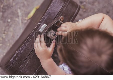 Adorable Baby Trying To Open A Suitcase With A Hair Clip