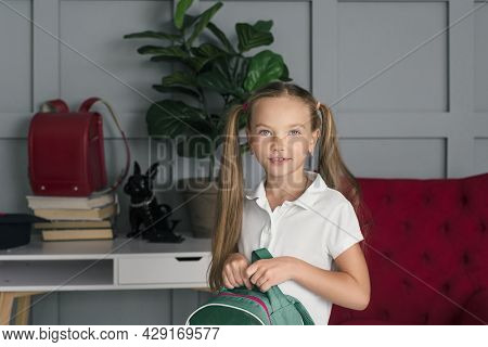 Happy Schoolchild In The Classroom With Big Backpack And Positive Emotions. Excieted And Ready To St