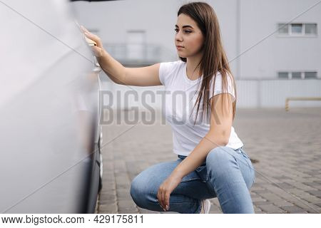 Front View Of Attractive Happy Joyful Female Driver Washing Her Car With Special Rag In Self-service