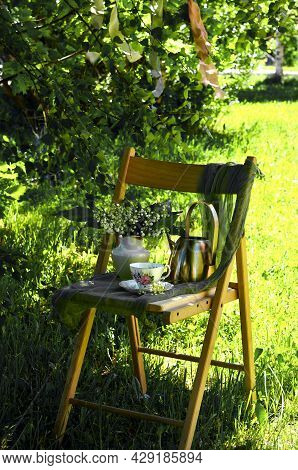 Summer Composition In The Garden On A Chair, Lilies Of The Valley And A Cup Of Tea, A Weekend In The
