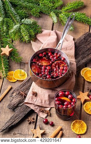 Hot Mulled Red Wine Drink With Citrus, Apples, Cinnamon Sticks, Cloves And Anise In Cooking Pan On W